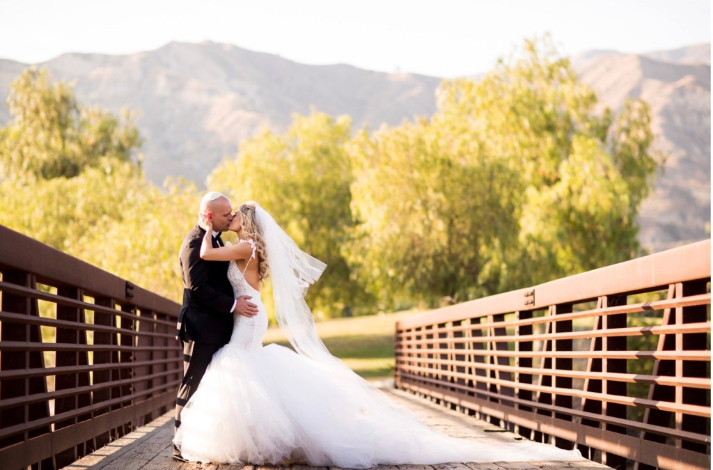 A bride wears a custom Lauren Elaine mermaid backless mermaid wedding gown with cathedral tulle train and veil in Los Angeles, CA at Angeles National Golf Club.