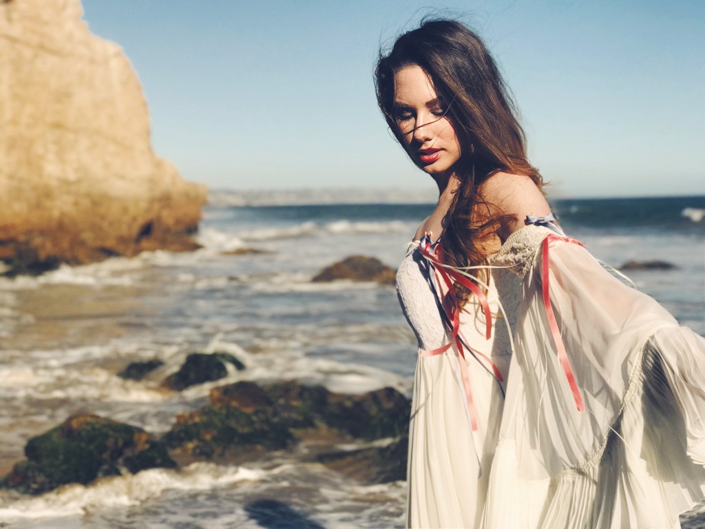 Designer Lauren Elaine poses for a fashion editorial feature at el matador beach in malibu in an ethereal wedding gown