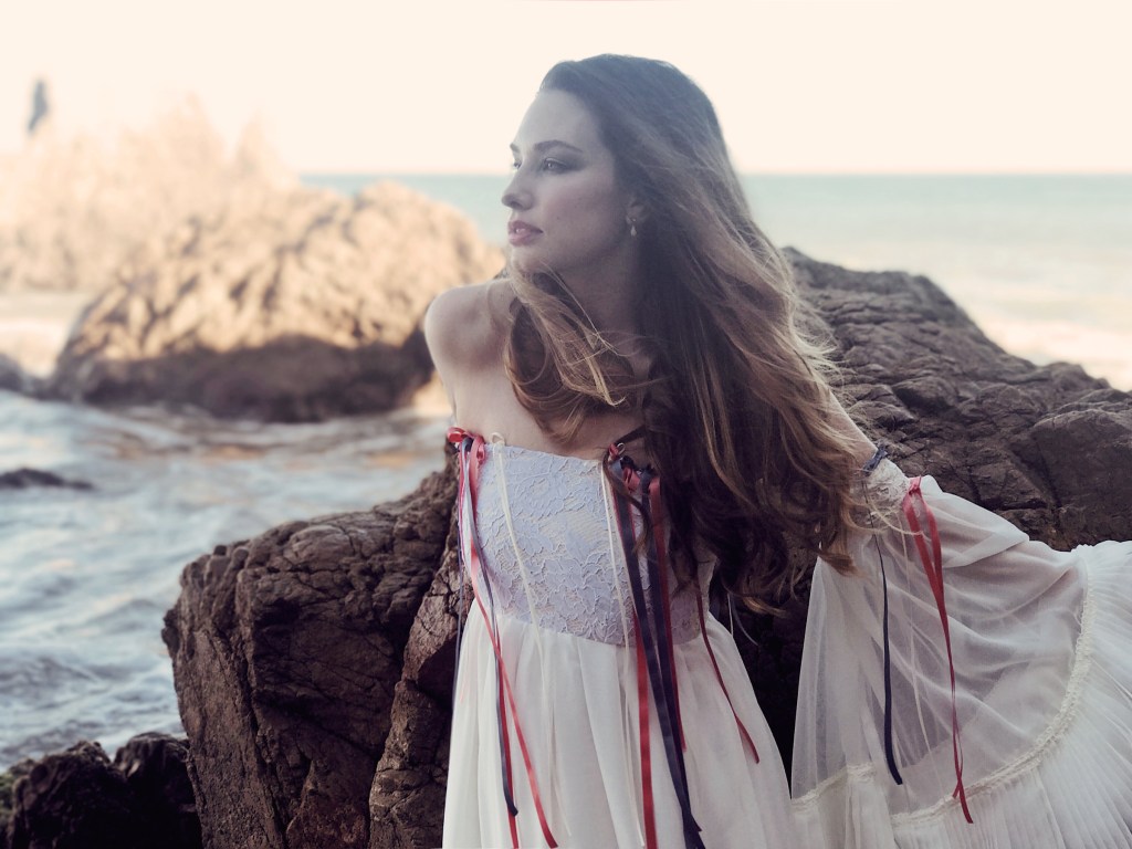 Editorial portrait of los angeles bridal designer lauren elaine posing in an off-the-shoulder lace wedding gown dress with ribbons