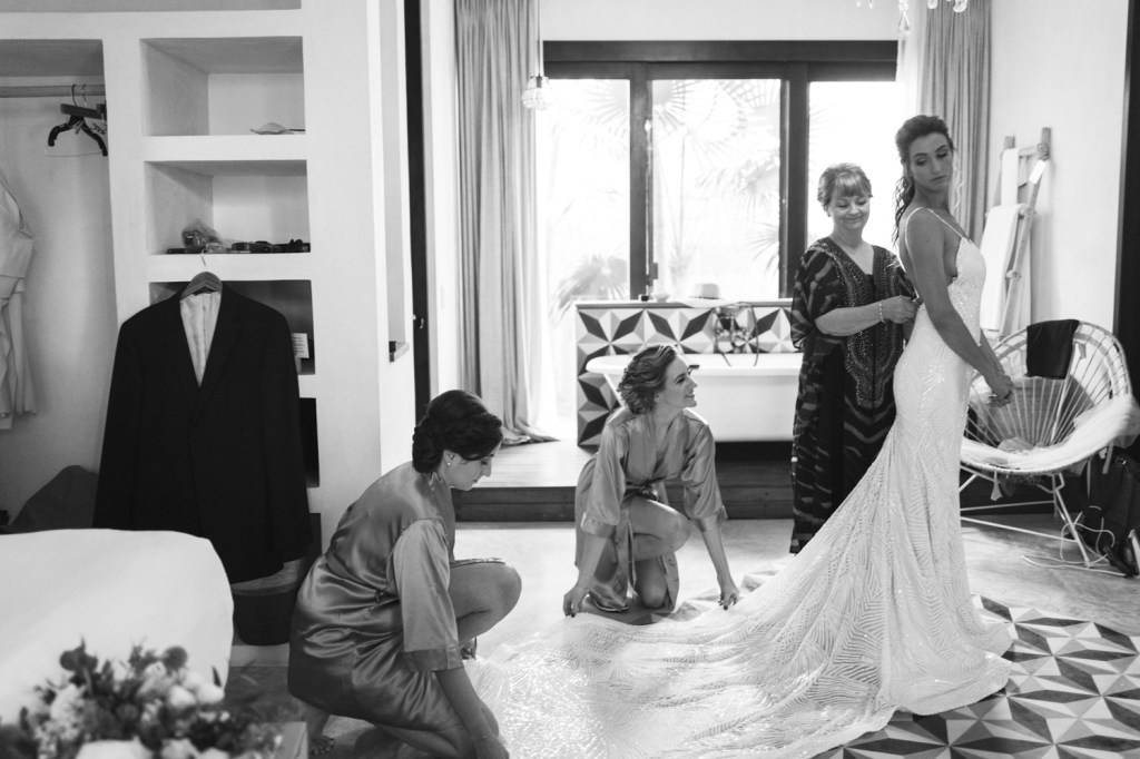 A bridal party helps bride Geniffer get ready in her custom Lauren Elaine "Prism" gown.