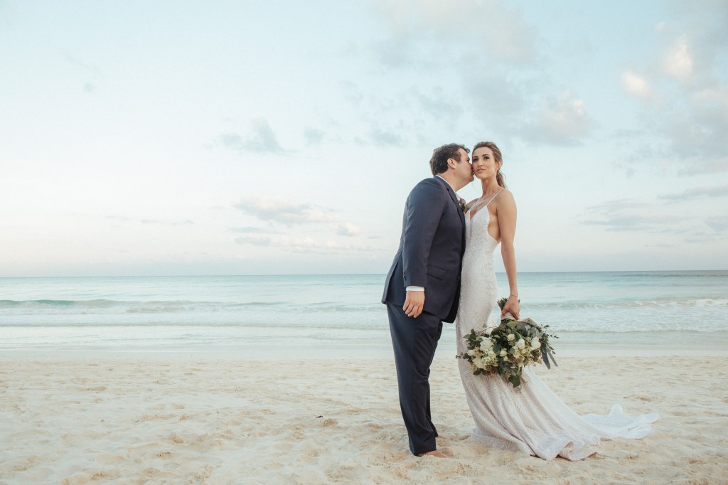 Bride Geniffer poses in her custom Lauren Elaine "Prism" wedding gown on a beach in Mexico.