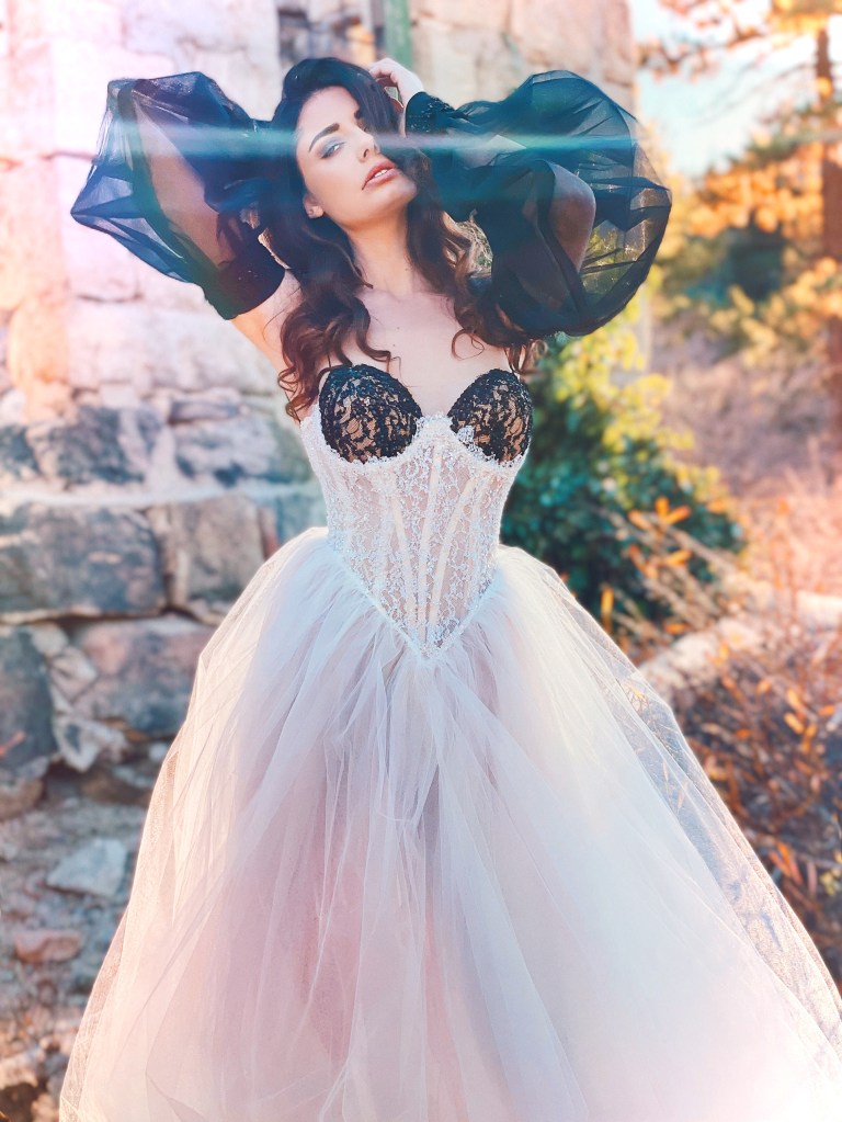 A model wears the Lauren Elaine "Salem" black and white bustier corset wedding gown.