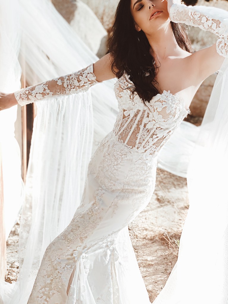 A model wears the Lauren Elaine Genesis lace applique bustier corset trumpet wedding dress.