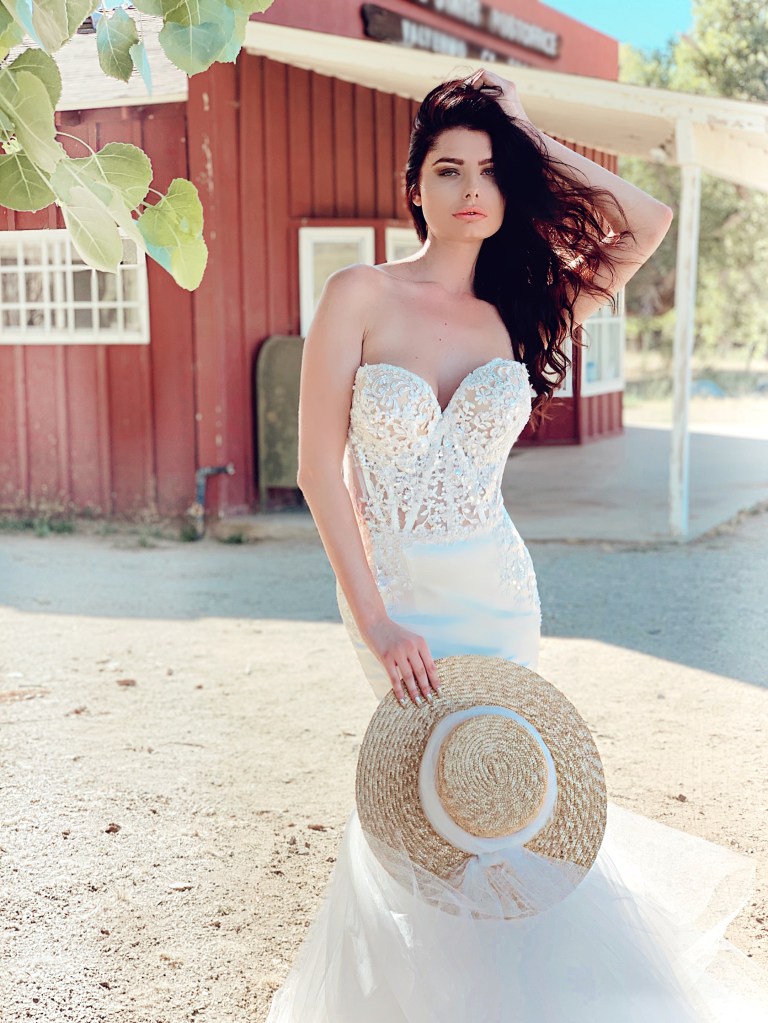 A model wears the romantic lace applique bustier corset wedding gown by Lauren ELaine Bridal.