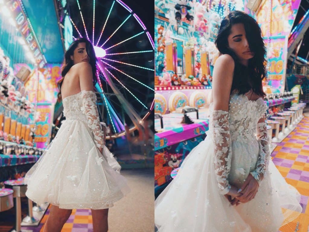 A model wears the Lauren Elaine Limelight mini wedding dress at a carnival