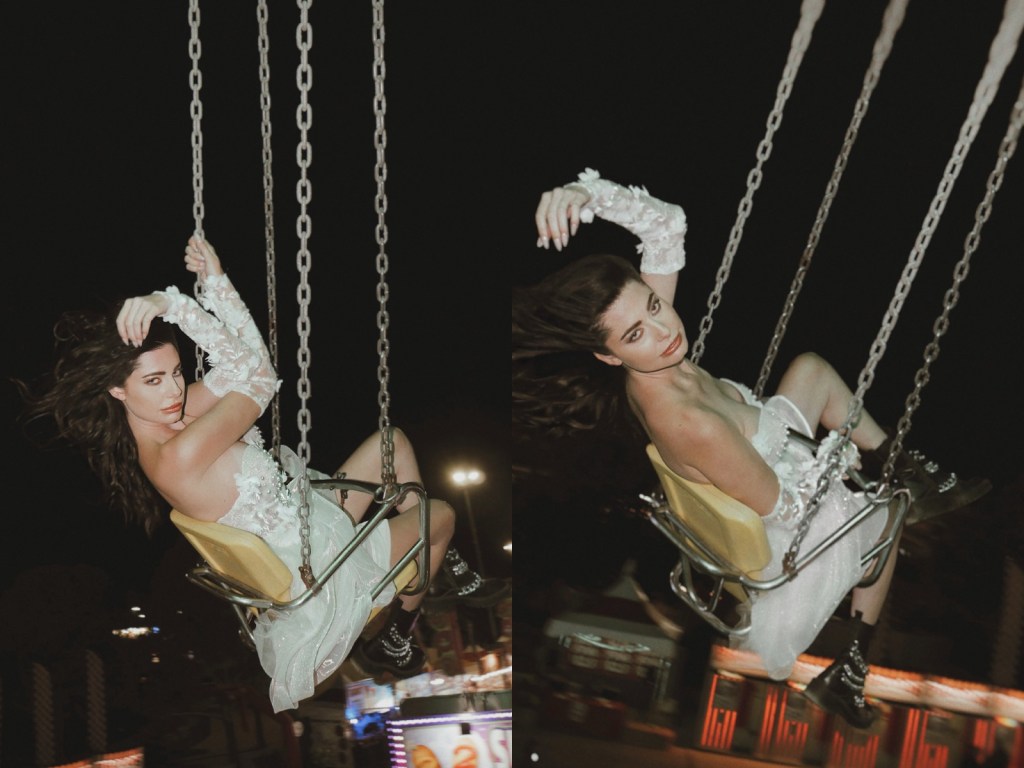 A model rides carnival swings in the Lauren Elaine Bridal Limelight Mini Dress