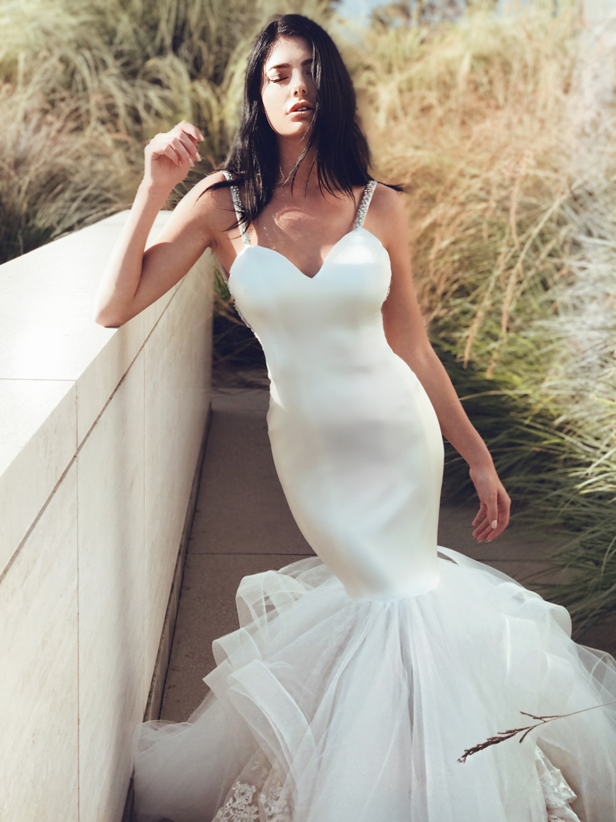 A model wears a satin mermaid wedding dress by Lauren Elaine
