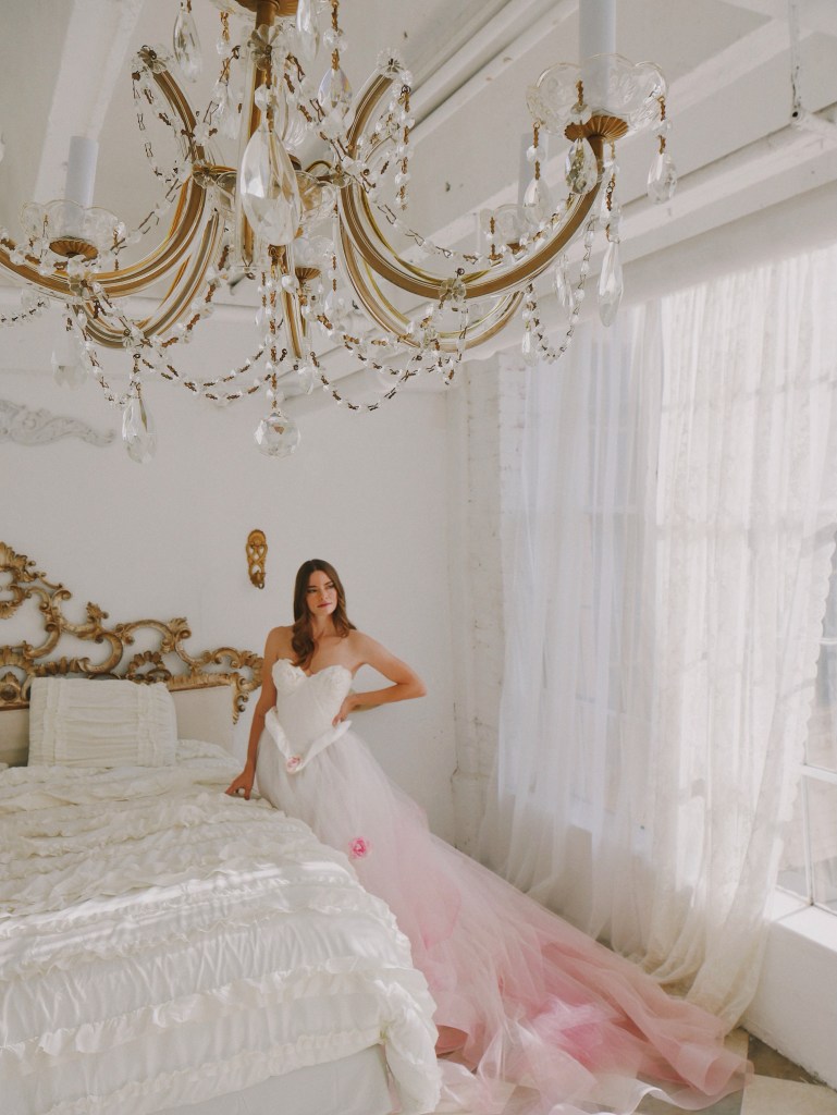 A model poses in the pink blush ombre "Duchess" wedding dress by Lauren Elaine.